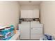 Bright laundry room with white washer and dryer, storage cabinets, and ample space at 950 N Sailors Way, Gilbert, AZ 85234