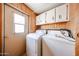 Laundry room with washer, dryer, and white cabinets at 10951 N 91St Ave # 16, Peoria, AZ 85345