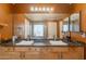 Bathroom with double sinks set in wood vanity with a large mirror and decorative lighting at 11526 W Bermuda Dr, Avondale, AZ 85392
