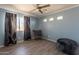 Light-filled bedroom with dark curtains, unique chair, and wood-look floors for a modern feel at 11526 W Bermuda Dr, Avondale, AZ 85392