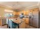 Spacious kitchen with stainless steel appliances, an island with seating, and granite countertops at 11526 W Bermuda Dr, Avondale, AZ 85392