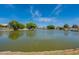 Lakeside living with serene water views, lush trees, and charming homes creating a peaceful neighborhood setting at 11526 W Bermuda Dr, Avondale, AZ 85392