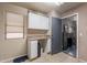Functional laundry room with white cabinets, countertop, and access to another space at 11526 W Bermuda Dr, Avondale, AZ 85392