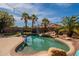 Backyard swimming pool featuring rock waterfall, mature palm trees, and string lights, perfect for relaxation at 11526 W Bermuda Dr, Avondale, AZ 85392