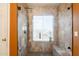 Shower featuring updated tile, a built-in bench, glass door and a rain shower head at 11526 W Bermuda Dr, Avondale, AZ 85392