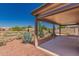 Covered patio with desert landscaping leading to a glimpse of a backyard pool, ideal for entertaining at 11543 W Sandsnake Ct, Surprise, AZ 85378