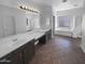 A spacious bathroom features double sinks, a large mirror with lighting, and a soaking tub at 13335 W Marlette Ct, Litchfield Park, AZ 85340