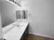 Well-lit bathroom with a long vanity, large mirror, and tiled flooring at 13335 W Marlette Ct, Litchfield Park, AZ 85340