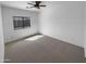 Light-filled bedroom with neutral carpet, white walls and ceiling fan for added comfort at 13335 W Marlette Ct, Litchfield Park, AZ 85340