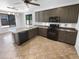 A modern kitchen features dark cabinetry, an island with a sink, and stainless steel appliances at 13335 W Marlette Ct, Litchfield Park, AZ 85340