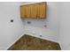 A clean, functional laundry room featuring overhead cabinets and essential appliance connections at 13335 W Marlette Ct, Litchfield Park, AZ 85340
