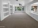 A spacious room is showcased with large windows overlooking a pool, complemented by built-in shelving at 13335 W Marlette Ct, Litchfield Park, AZ 85340