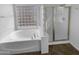 A luxurious bathroom with a soaking tub and a separate glass enclosed shower at 13335 W Marlette Ct, Litchfield Park, AZ 85340