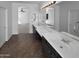 Bathroom featuring dual sinks, a large mirror, and tile flooring at 13335 W Marlette Ct, Litchfield Park, AZ 85340