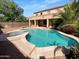Backyard view of the pool and spa, complimented by lush landscaping and a desert backdrop at 13335 W Marlette Ct, Litchfield Park, AZ 85340