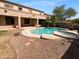 A backyard with a sparkling pool and spa, surrounded by desert landscaping and a covered patio at 13335 W Marlette Ct, Litchfield Park, AZ 85340