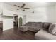 Open concept living room featuring a comfortable gray couch and dark wood floors at 1402 E Guadalupe Rd # 234, Tempe, AZ 85283