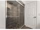 Elegant walk-in shower featuring decorative stone base, gray tiled wall, and glass door at 1402 E Guadalupe Rd # 234, Tempe, AZ 85283