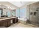 Elegant bathroom featuring a soaking tub, walk-in shower and double sink vanity at 14717 N 97Th Pl, Scottsdale, AZ 85260