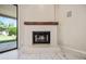Elegant fireplace with wooden mantel and marble tile surround at 14717 N 97Th Pl, Scottsdale, AZ 85260