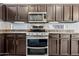 Modern kitchen featuring stainless steel appliances, granite countertops, and custom cabinets at 14717 N 97Th Pl, Scottsdale, AZ 85260