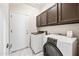 Laundry room with washer, dryer, upper cabinets and marble floors at 14717 N 97Th Pl, Scottsdale, AZ 85260