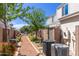 Landscaped backyard path with colorful flowers and air conditioning units between homes at 1600 N Saba St # 143, Chandler, AZ 85225