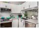 Well-lit kitchen features stainless steel appliances, white cabinetry, subway tile backsplash, and modern fixtures at 1600 N Saba St # 143, Chandler, AZ 85225
