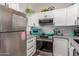 Modern kitchen with white cabinets, stainless steel appliances, and stylish fixtures at 1600 N Saba St # 143, Chandler, AZ 85225