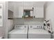 Bright laundry room equipped with a washing machine and dryer with overhead cabinet and storage space at 1600 N Saba St # 143, Chandler, AZ 85225