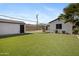 Backyard featuring green turf, a detached garage, and desert landscaping at 1615 E Roma Ave, Phoenix, AZ 85016