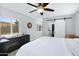 Bright bedroom boasts a ceiling fan, hard floors, an attached bathroom with white sliding door at 1615 E Roma Ave, Phoenix, AZ 85016