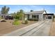 Well-kept home features a charming exterior, long driveway, and desert-friendly landscaping at 1615 E Roma Ave, Phoenix, AZ 85016