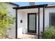 Close-up of the home's entry, complete with a black-trimmed, glass front door and desert plants at 1615 E Roma Ave, Phoenix, AZ 85016