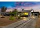 Beautifully landscaped single-story home featuring a long driveway and a detached garage at 1615 E Roma Ave, Phoenix, AZ 85016