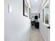 Hallway with wood-look floors leads to an office space, with pictures lining the walls and window providing light at 1615 E Roma Ave, Phoenix, AZ 85016
