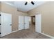 Neutral bedroom with neutral carpet featuring a ceiling fan and access to other rooms at 1621 W Wildwood Dr, Phoenix, AZ 85045
