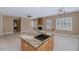 Tile flooring, a fireplace, kitchen island with a cooktop and overhead lighting can be seen in this interior shot at 1621 W Wildwood Dr, Phoenix, AZ 85045