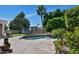 An inviting pool on the back patio sits next to lush grass, landscaping and mature palm trees in the green backyard at 1621 W Wildwood Dr, Phoenix, AZ 85045