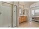 Stylish bathroom with a walk-in shower and a vanity featuring wooden cabinets and dual mirrors at 16420 N Thompson Peak Pkwy # 1002, Scottsdale, AZ 85260