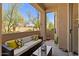 Cozy patio with a comfortable cushioned sofa and lovely green outdoor views at 16420 N Thompson Peak Pkwy # 1002, Scottsdale, AZ 85260