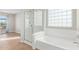 Bright bathroom featuring a glass shower, a tub, and a glass block window for natural light at 16527 W Ironwood St, Surprise, AZ 85388