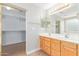 Bathroom with a dual sink vanity and a walk-in closet, offering convenience and ample storage space at 16527 W Ironwood St, Surprise, AZ 85388