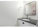 Bathroom featuring a white vanity with black countertop, modern fixtures, and an elegant mirror at 16527 W Ironwood St, Surprise, AZ 85388