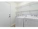 Bright laundry room with washer, dryer and wire shelving at 16527 W Ironwood St, Surprise, AZ 85388