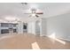 Open concept living area flows to kitchen with stainless appliances, wood flooring, and ceiling fans at 16527 W Ironwood St, Surprise, AZ 85388