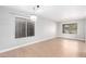 Bright, light-filled living room with wood floors and two large windows at 16527 W Ironwood St, Surprise, AZ 85388