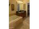 Bathroom showcasing a soaking tub adjacent to a double sink vanity and an open closet at 16820 E La Montana Dr # 105, Fountain Hills, AZ 85268