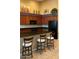 A modern kitchen with dark countertops, wood cabinets, a breakfast bar, and stainless steel appliances at 16820 E La Montana Dr # 105, Fountain Hills, AZ 85268