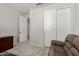 Bedroom featuring neutral walls, carpeted floors, a couch, and a closet with sliding doors at 18021 W Avenida Del Sol --, Surprise, AZ 85387